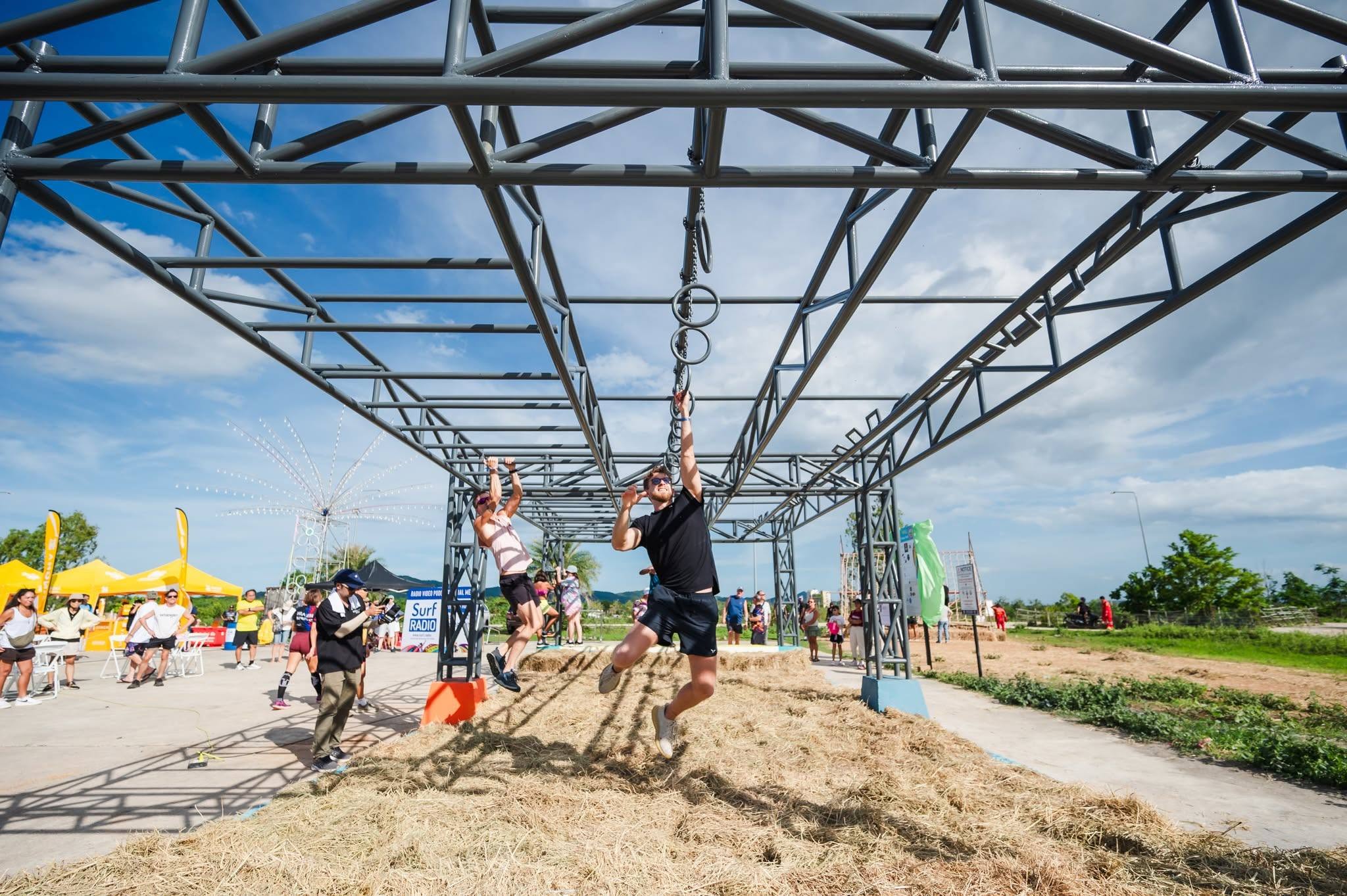Participants running along an outdoor obstacle course